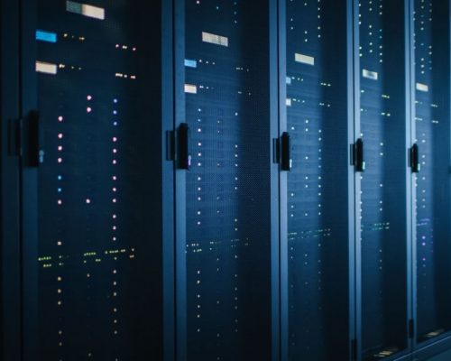 Shot of Dark Data Center With Multiple Rows of Fully Operational Server Racks. Modern Telecommunications, Cloud Computing, Artificial Intelligence, Database, Supercomputer. Blue Neon Light.